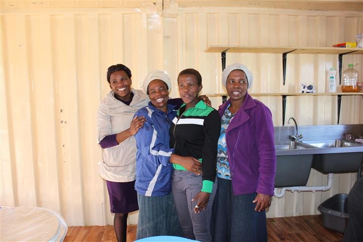 Volunteers in Freedom Park, South Africa in their newly refurbished kitchen which provides food for over 200 Orphaned and Vulnerable Children daily